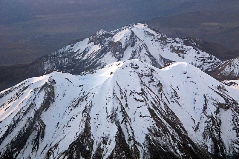 Looking down at snowcapped peaks from the plane