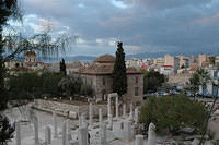 Some_ruins_with_newer_buildings_in_the_background.jpg